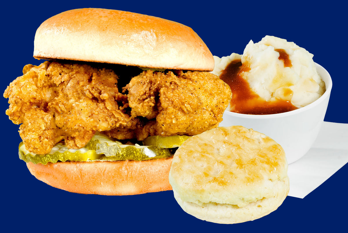 Fried chicken sandwich with biscuit and mashed potatoes on a blue background